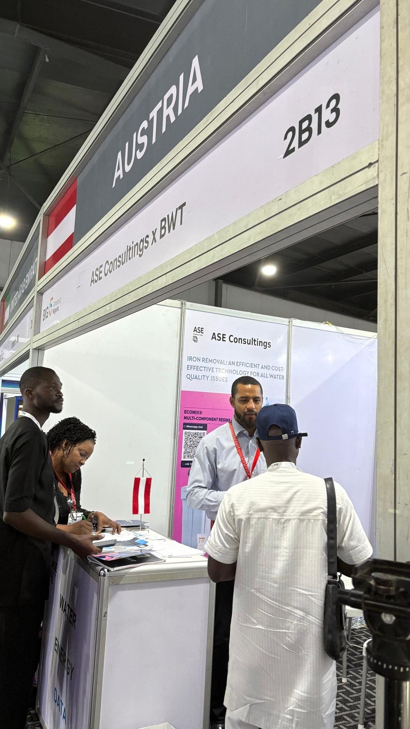 The ASE Consultings x BWT stand under the Austria pavilion sign, with visitors at the counter