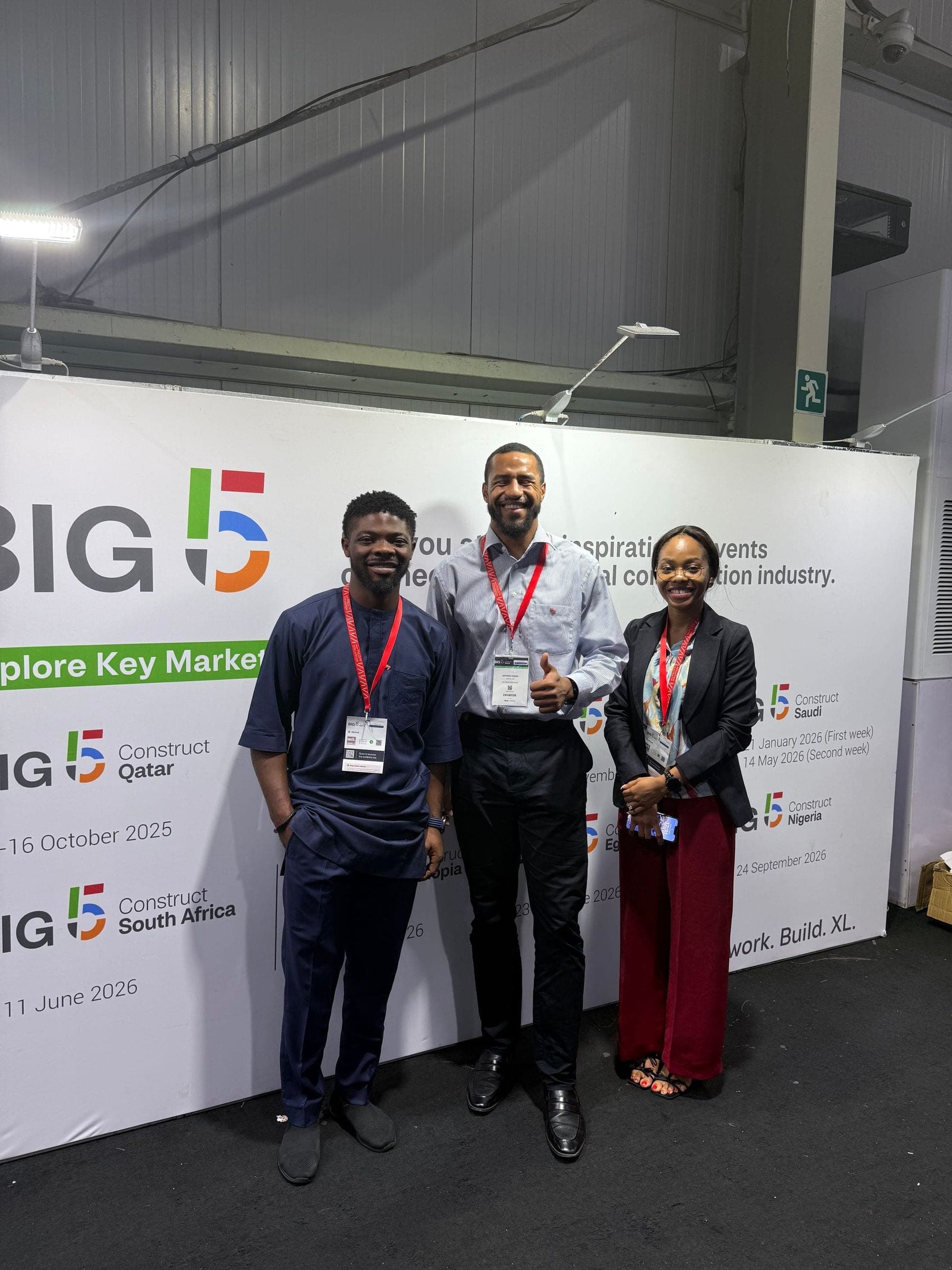 Three exhibitors in front of the Big 5 Construct wall