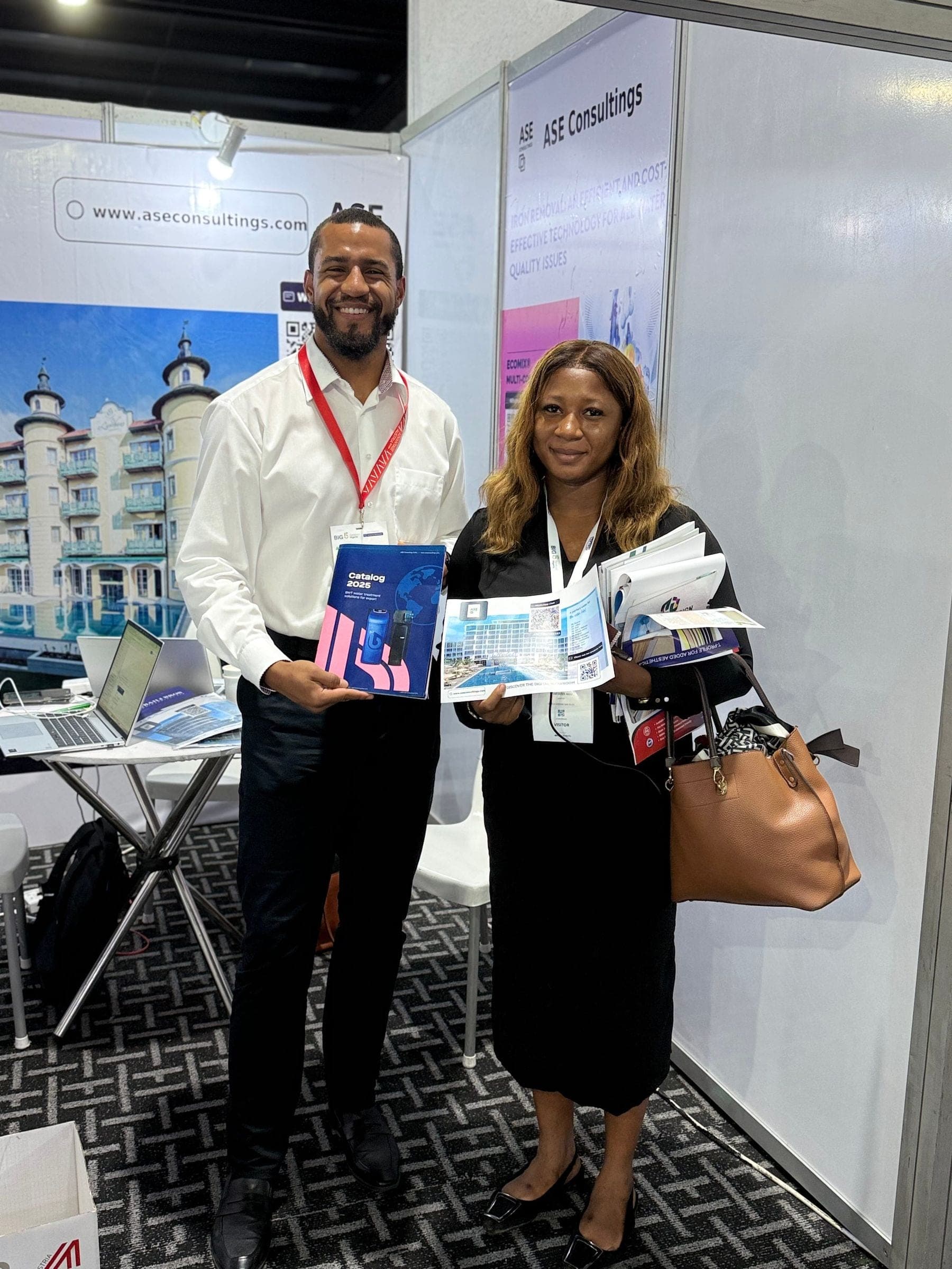 Two exhibitors holding BWT brochures at the stand