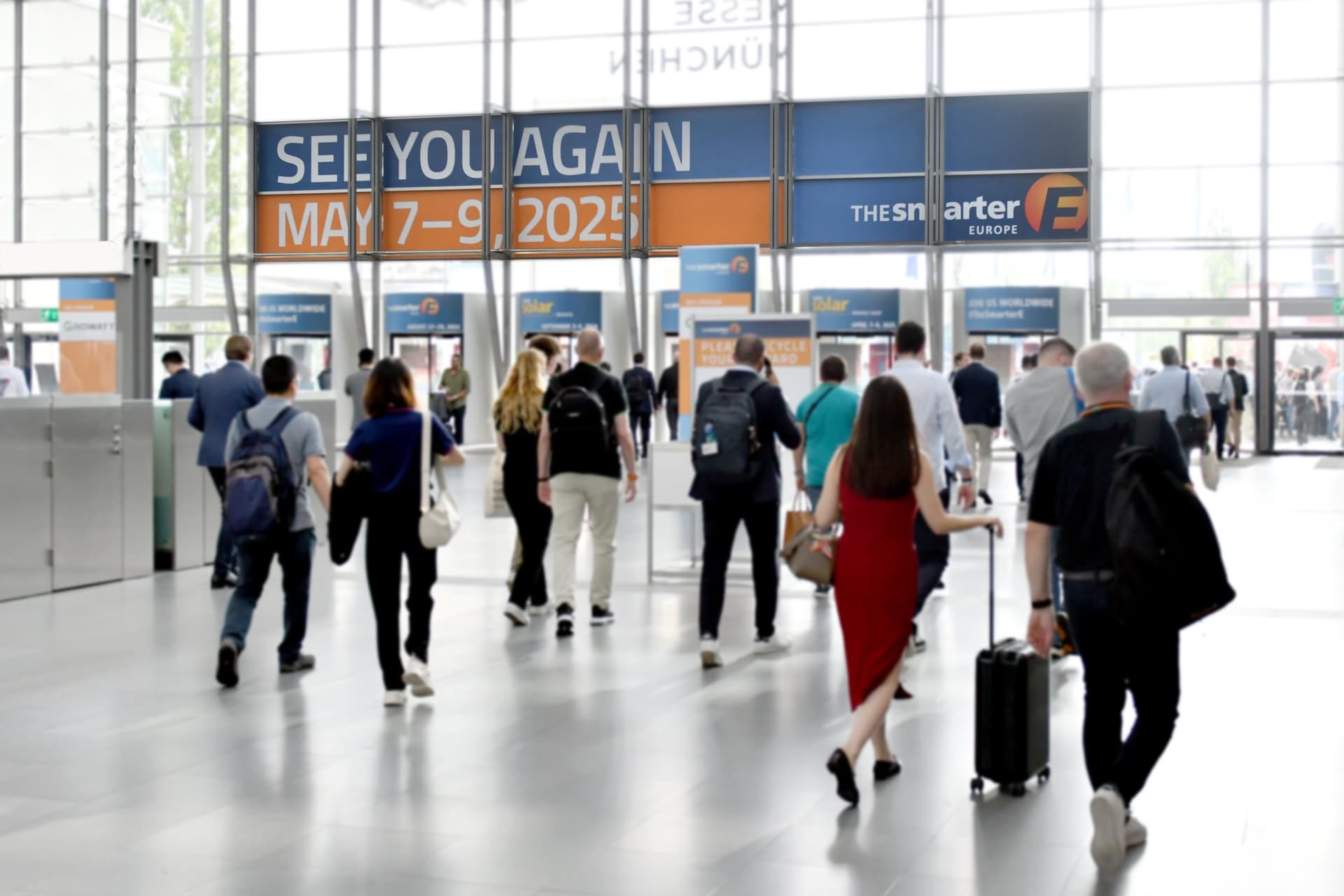 Visitors leaving on the closing day, under banners announcing the 2025 dates