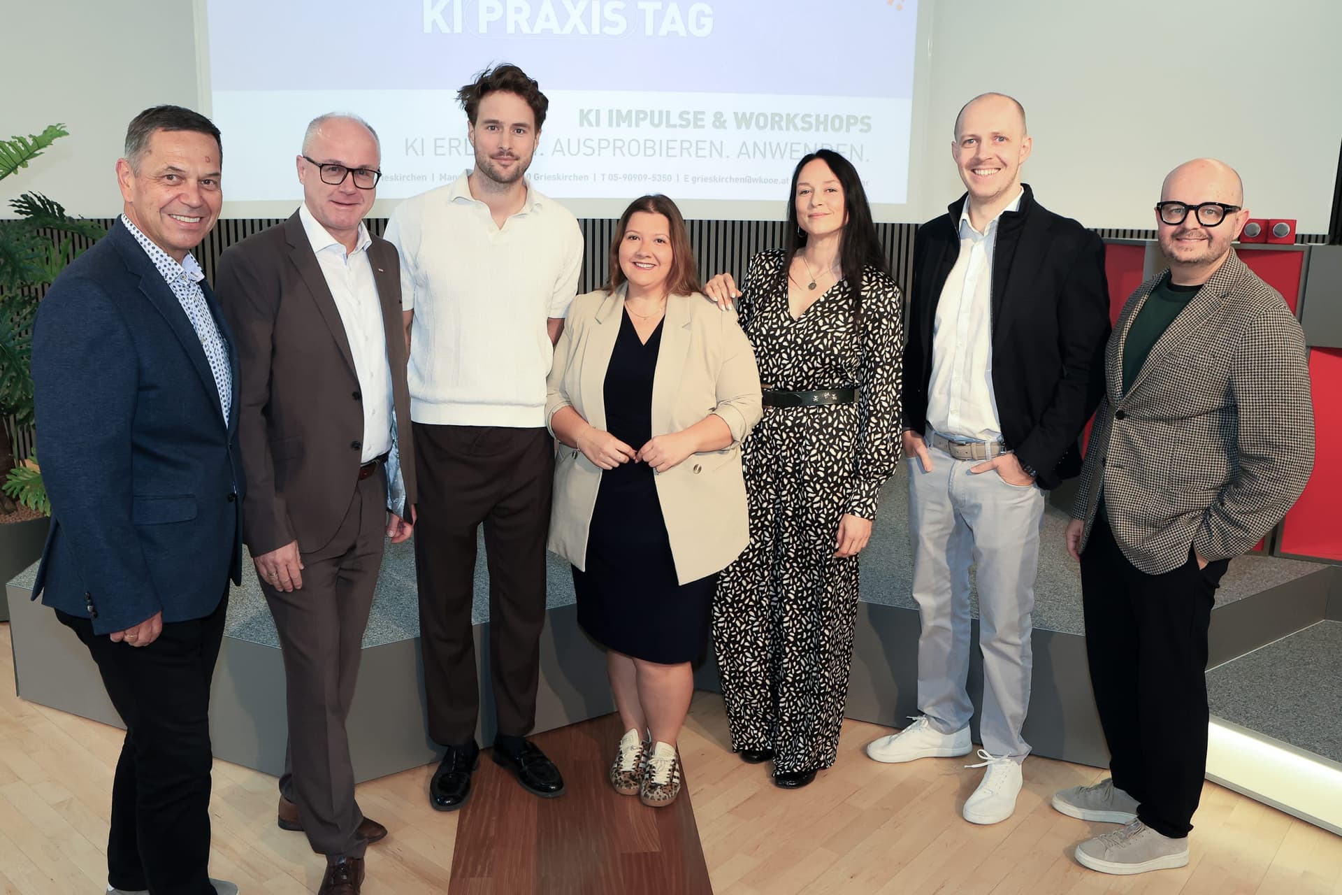 Organisers and presenters of the KI-Praxistag, from WKO Grieskirchen, WKO Upper Austria, zflys, Ahoi Kapptn and deine KI Agentur, standing in front of the KI PRAXIS TAG slide