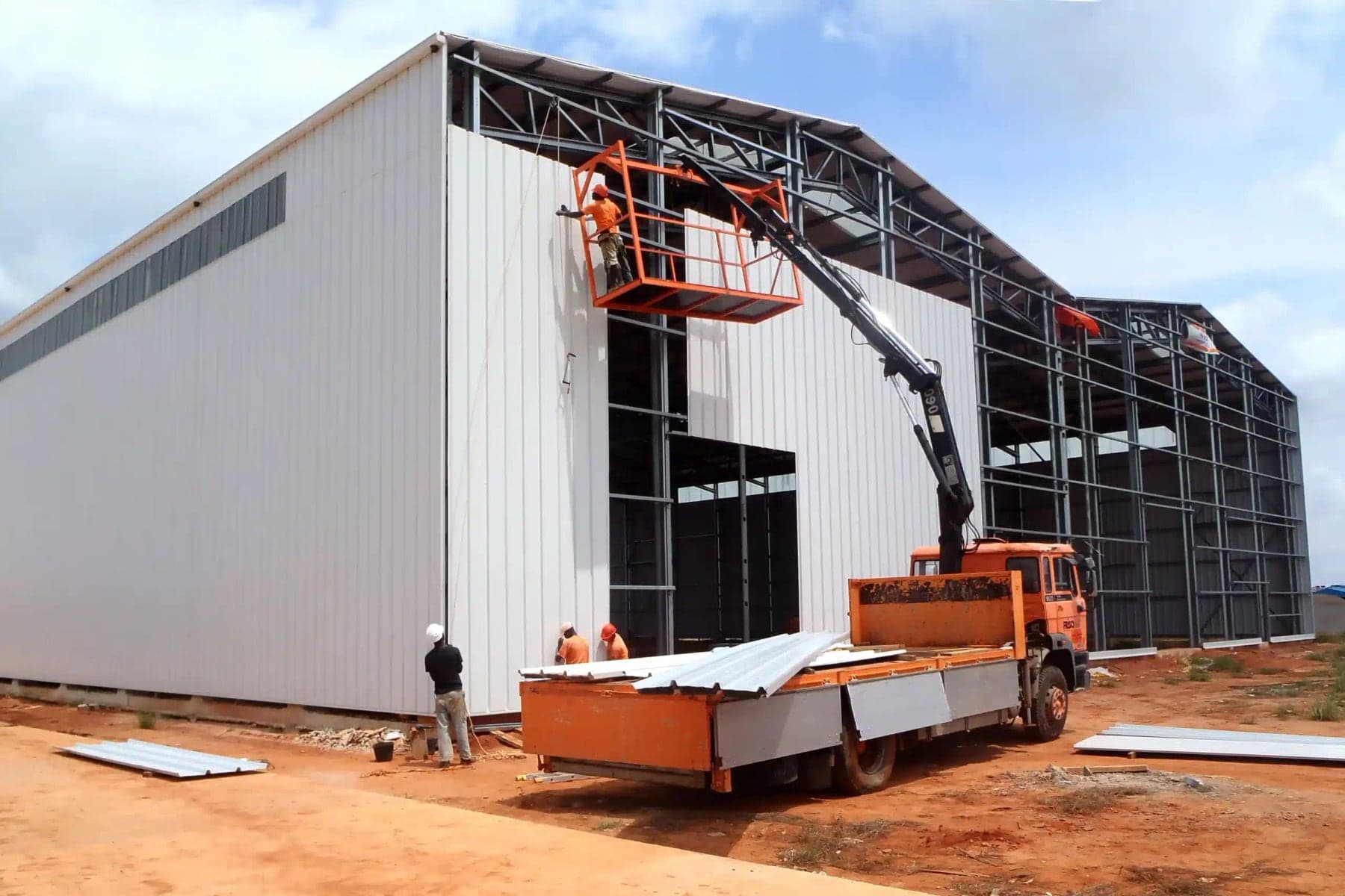 Industrial production facility under construction with elevated access equipment