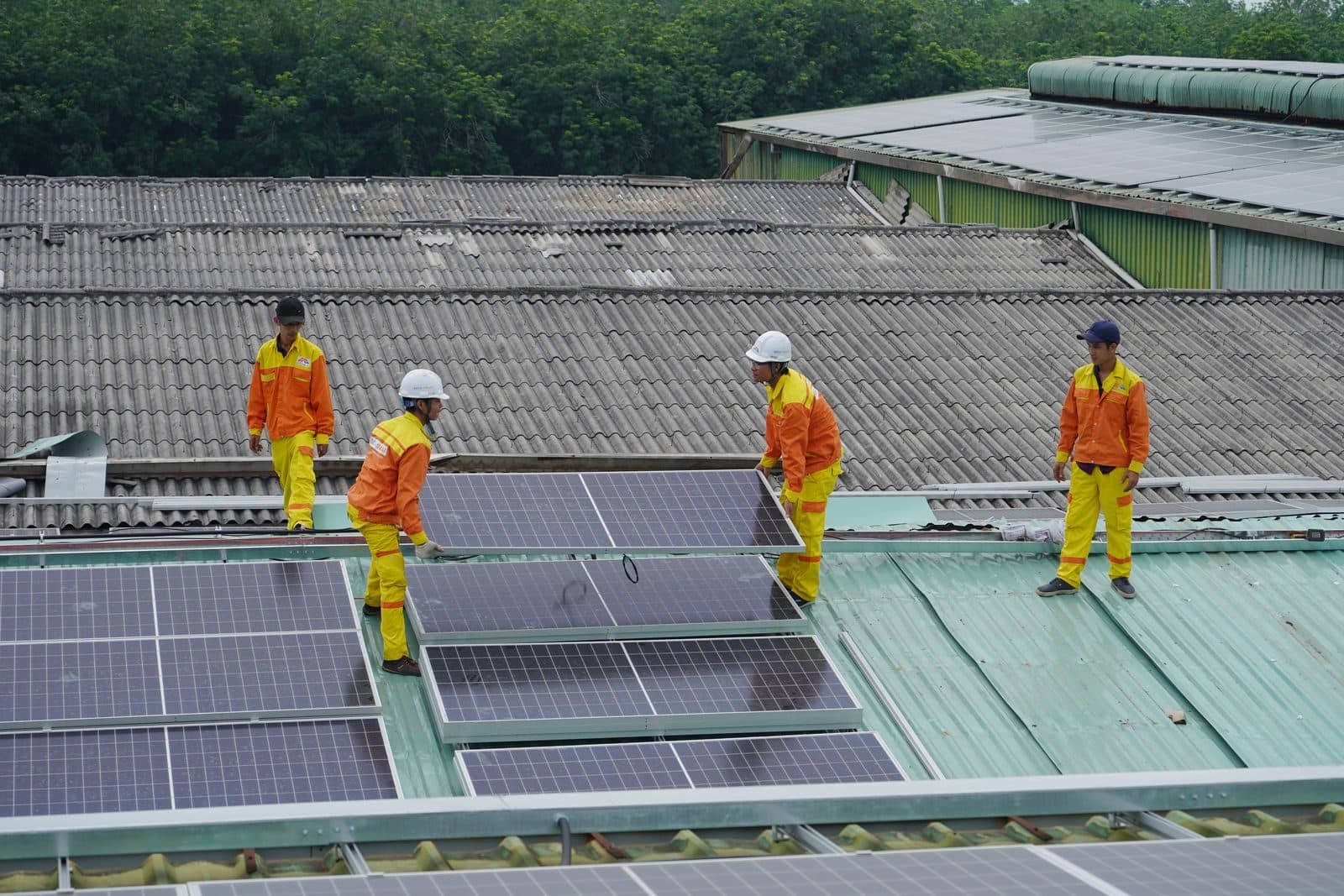 Crew installing solar panels on an industrial roof