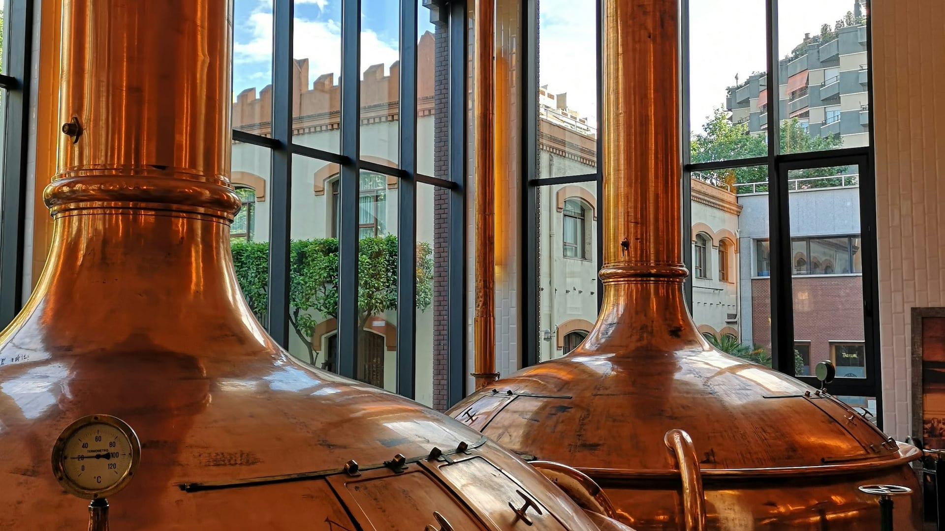 Polished copper brewhouse kettles — process equipment sized against the product